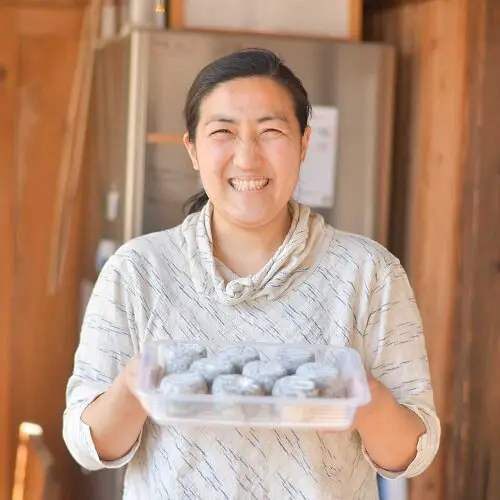 Shibata sosteniendo una versión envejecida del Bamboo Charcoal Takesumi.  crédito de la foto Fromagerie Sen